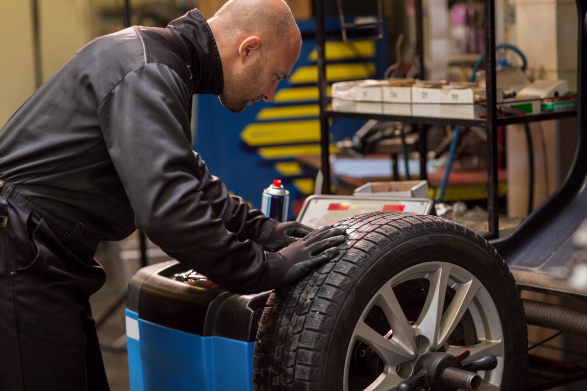 mechanic balancing a tire in the auto shop 